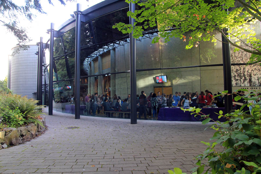 A view from outside the Chan Centre, looking in to students mingling in the lobby.